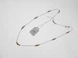 gros plan d'un collier sur une surface blanche avec une étiquette de prix