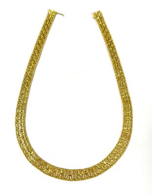 a close up of a gold necklace on a white background