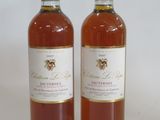 two bottles of wine sitting next to each other on a white surface