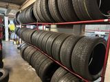 tires are stacked on a rack in a tire shop