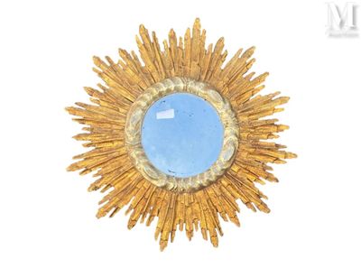 a blue stone in the center of a gold sunburst