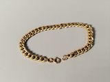a gold chain bracelet on a white background