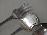two spoons and a fork sitting on a table