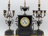 une image représentant une horloge et quatre bougies posées sur une table