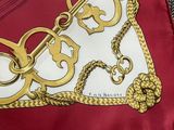 a picture of a scarf with a gold chain on it