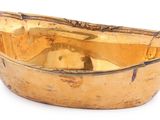 a gold bowl that is sitting on a white surface