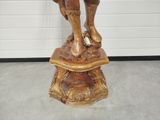 a statue of a man holding a dog on a pedestal