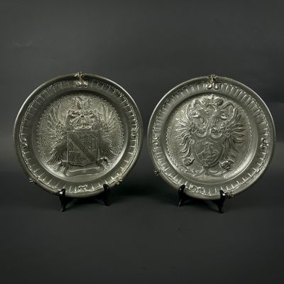 une paire d'assiettes en argent plaqué ornées de l'image d'un lion et d'une tête de lion