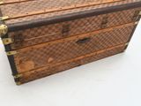 a brown and white checkered trunk sitting on a white surface