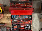 de nombreux outils dans une boîte à outils rouge posée sur une palette