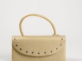 un sac à main beige orné de rivets et de clous sur la poignée