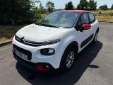 la petite voiture blanche est garée sur le bord de la route