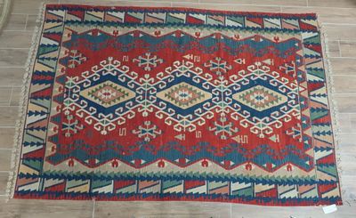 a red, blue and green rug on a tiled floor
