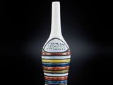 un vase blanc orné d'un motif multicolore