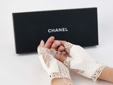 someone is holding a pair of white gloves on a white surface