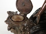a bronze statue of a woman holding a teapot