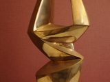 a bronze sculpture on a wooden base on a table