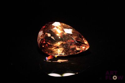 un gros plan d'un gros diamant orange sur une surface noire