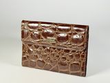 a brown alligator leather wallet with a chain around it