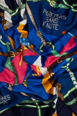 a close up of a blue and yellow scarf with a picture of a man on a skateboard