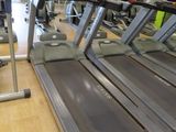 row of treads in a gym room with mirrors on the wall