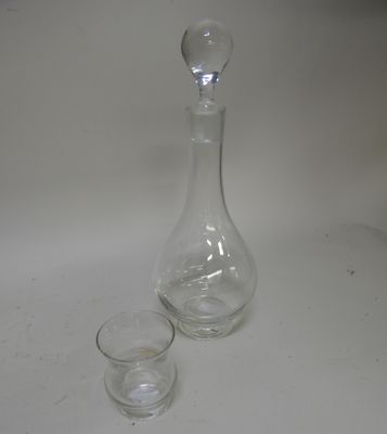 a glass and a decanter sitting on a table