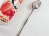 a can of soda next to a spoon on a table