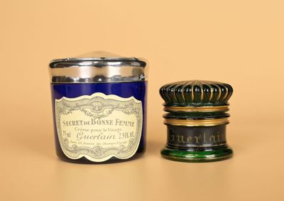 une bougie bleue et un bocal en verre vert posés sur une table