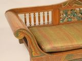 a wooden bench with a green cushion on it