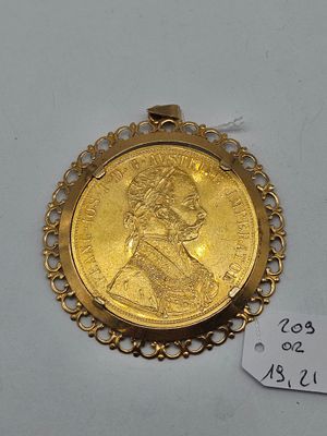 a close up of a gold coin on a white surface with a price tag