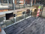 a long table with four chairs in front of a glass wall