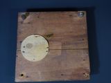 a wooden box with a hole in it on a blue surface