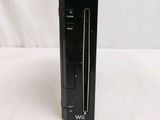 a black video game console sitting on a white surface