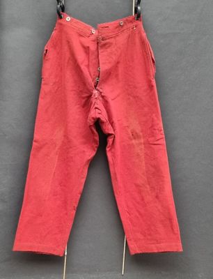 un pantalon rouge suspendu à une corde à linge
