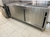 a large stainless steel kitchen with a sink and refrigerator