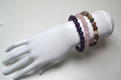 deux bracelets posés sur la main d'un mannequin, posée sur une table blanche