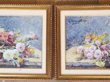 two paintings of flowers are hanging on a wall in a room