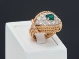 an emerald and diamond ring on display in a white box