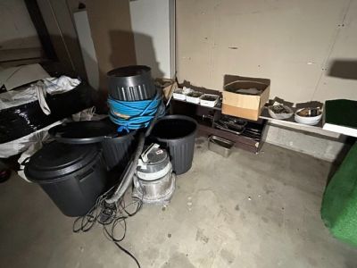 une pièce où il y a beaucoup de poubelles et d'autres objets par terre