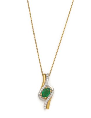 an emerald and diamond pendant on a gold chain