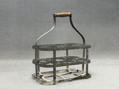 un petit porte-bouteille en métal muni d'une poignée en bois