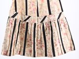 striped skirt with flowers and black stripes hanging on a hanger