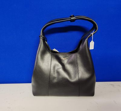 un sac à main en cuir noir posé sur une table, sur fond bleu
