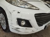 a white car that has been damaged and is in a garage
