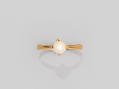 une bague en or avec une perle blanche au centre