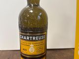 une photo d'une bouteille de whisky Chartreuse posée sur une table en bois