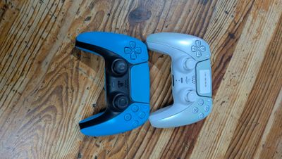 deux manettes de jeux vidéo posées sur un parquet