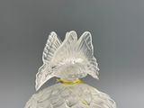 a glass vase with a bird on top of it