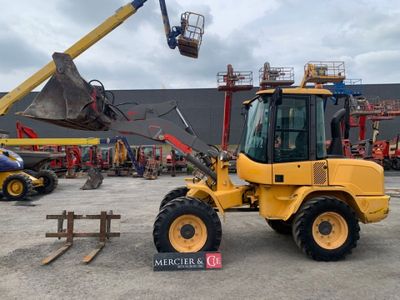 un gros engin de chantier jaune garé sur un parking