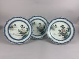 three blue and white plates with flowers and trees on them
